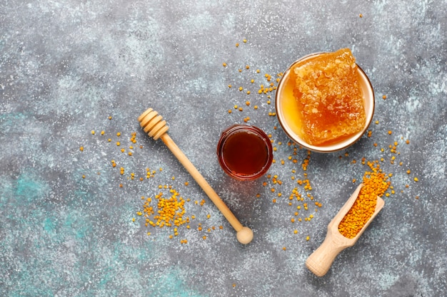 Various kinds of honey in glass jars,honeycomb and pollen.
