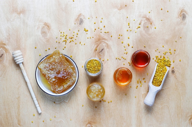 Vari tipi di miele in barattoli di vetro, favo e polline.