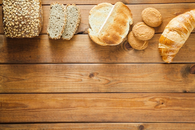 Various loaves of bread on wood