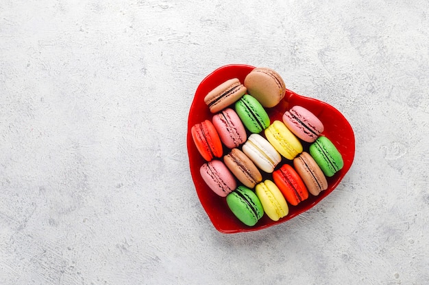 Various macaroons with pistachios, fruits, berries, coffee beans.