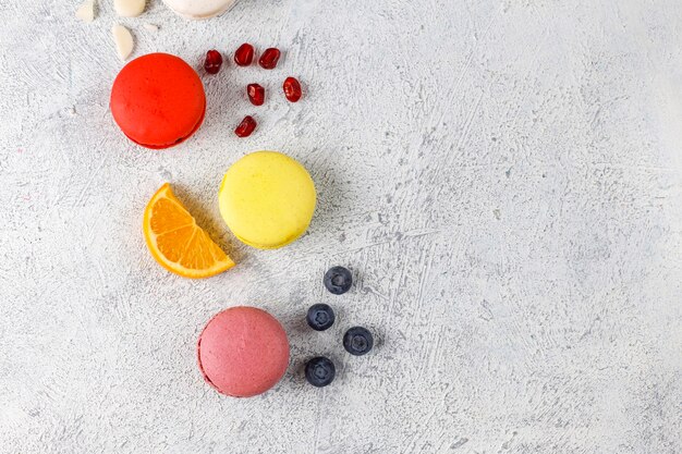 Various macaroons with pistachios, fruits, berries, coffee beans.