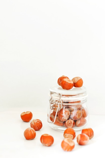 Various nuts selection: hazelnuts, pistachio and pecans in glass jars