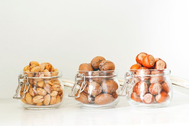 Various nuts selection: hazelnuts, pistachio and pecans in glass