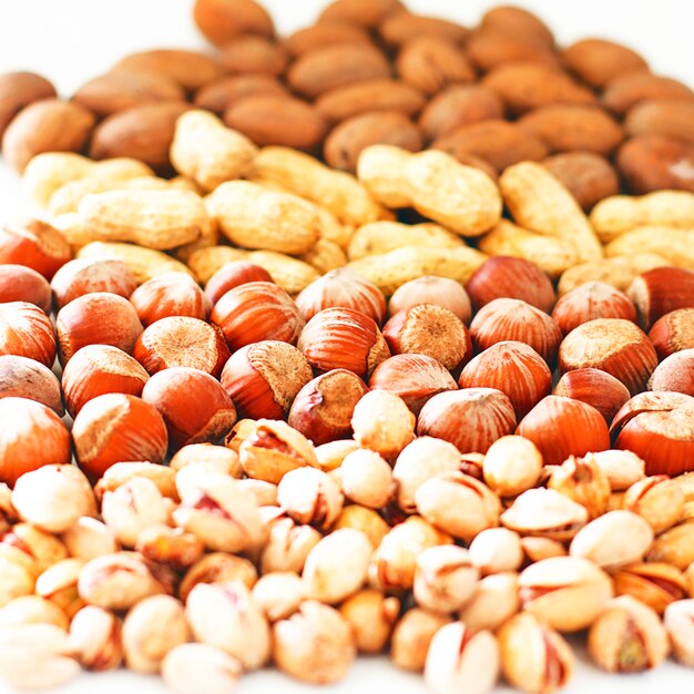 Various nuts selection: hazelnuts, pistachio and pecans in glass