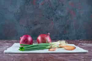 Free photo various onions on a towel on the marble surface