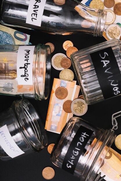 Various open jar with euro currency note and coins on black background