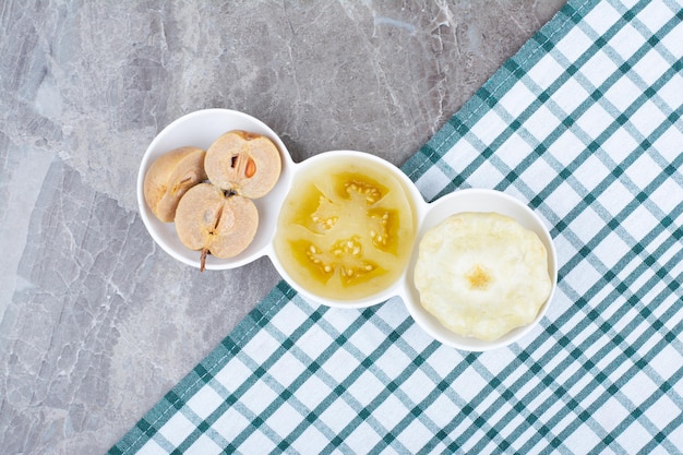 Various pickled vegetables and fruits in bowls with tablecloth. High quality photo