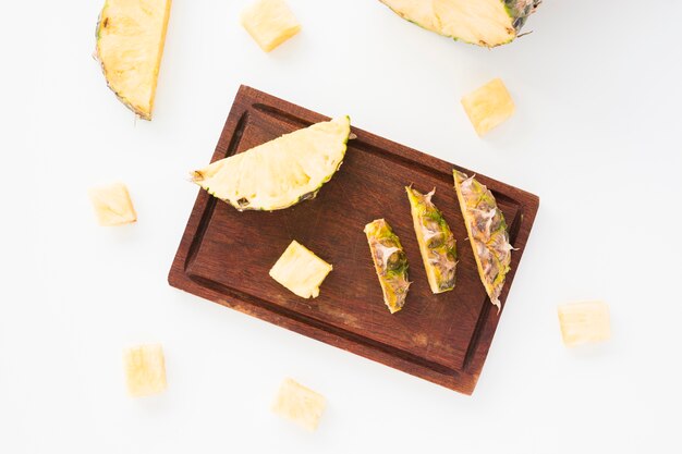 Various pineapple slices and leaves on white background