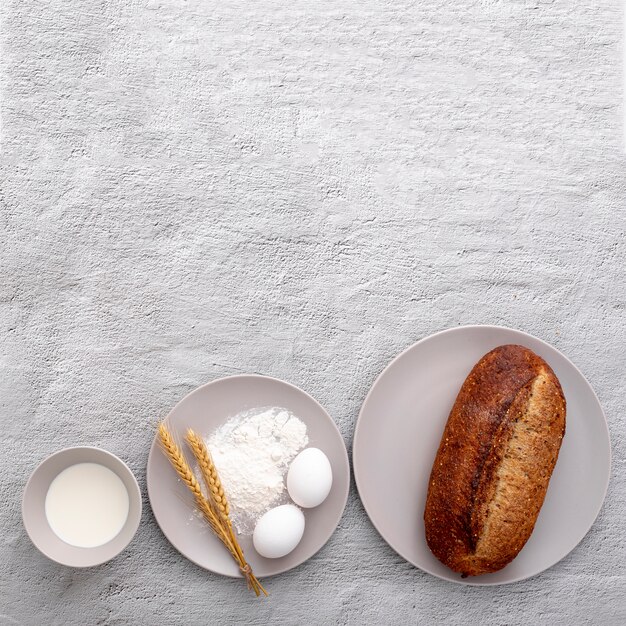 Various plates with eggs and bread on copy space background