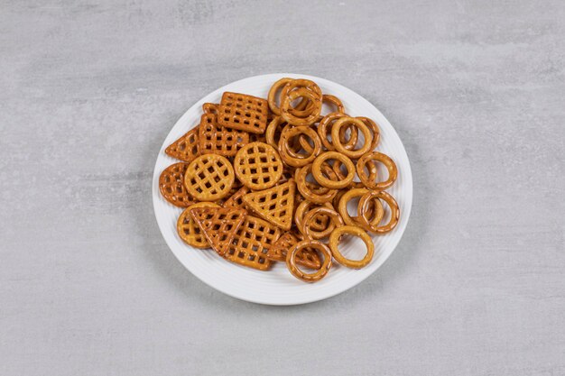 Various salty crackers on white plate.