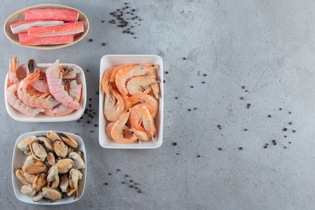 Various sea products in bowls , on the marble background. 