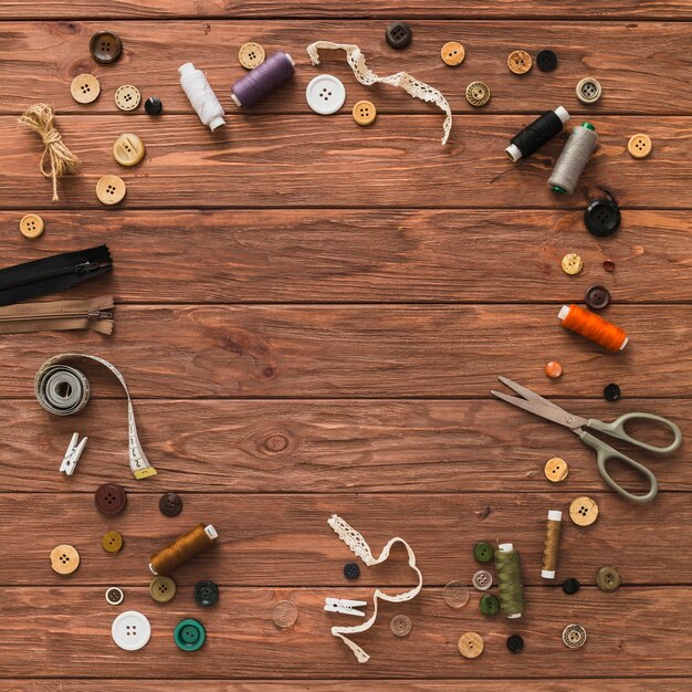 Various sewing accessories forming circle on wooden plank