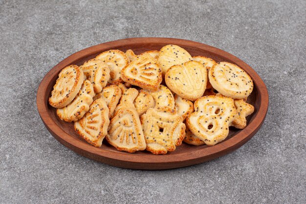 Various shaped biscuits on wooden plate