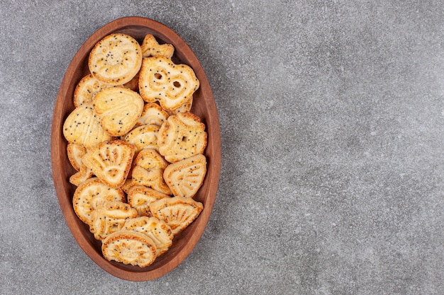 Various shaped biscuits on wooden plate