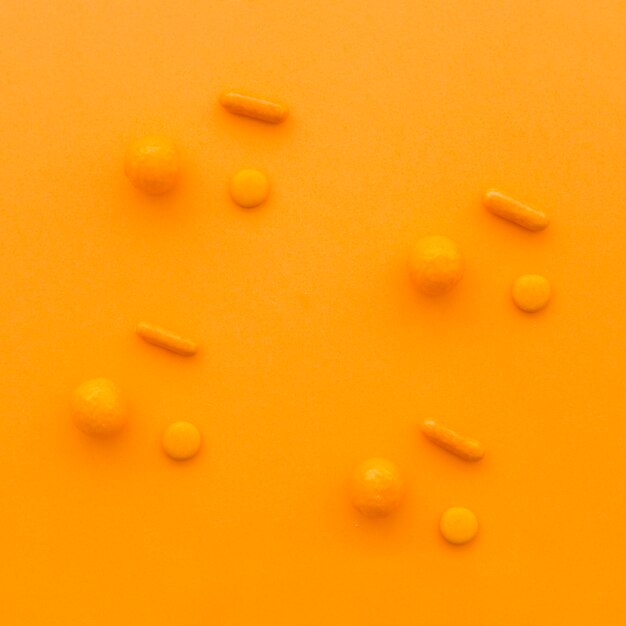 주황색 배경에 다양한 모양의 사탕