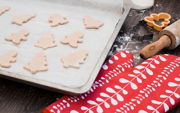 Free photo various shaped of cookie dough on baking sheet