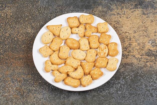 Various shaped salted crackers on white plate. 