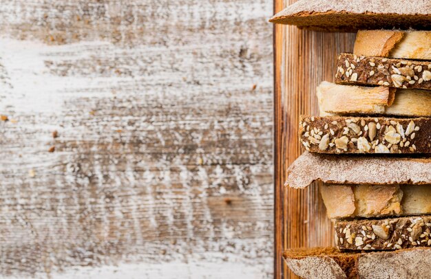 Различные ломтики свежего хлеба в деревянный поднос