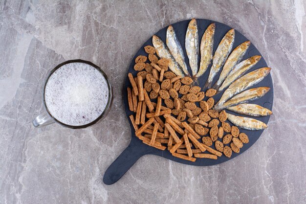 Foto gratuita vari snack e bicchiere di birra sulla superficie di marmo. foto di alta qualità