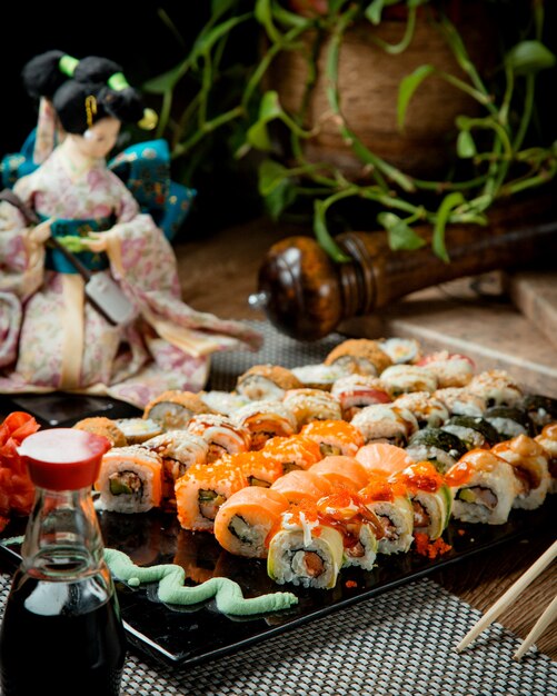 various sushi on a tray with wasabi and soy sauce