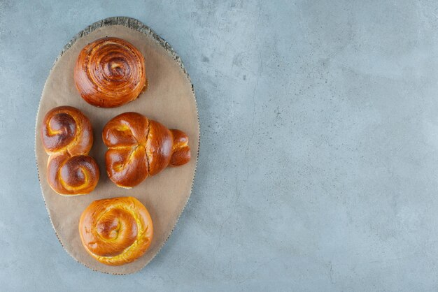 Various sweet pastries on wooden piece.