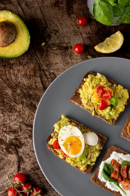 Various toasts with veggie cream on wooden table