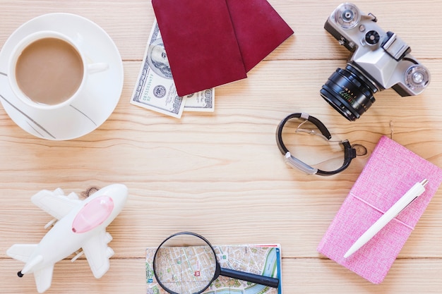 Various traveler accessories with tea cup on wooden background