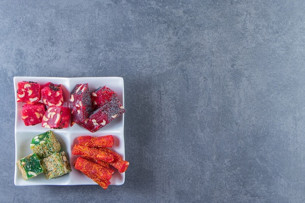 Various Turkish delights on a dish , on the marble background.