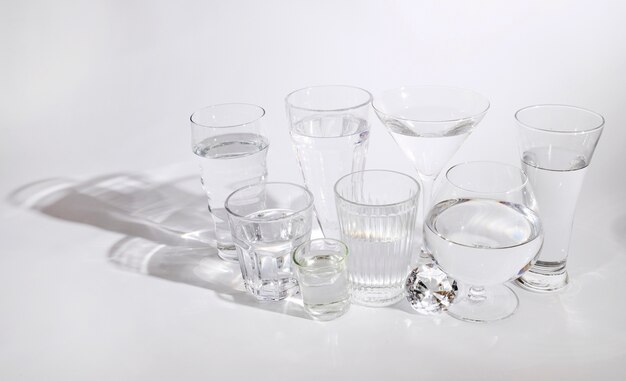 Различные виды стаканов с чистой водой на белом фоне