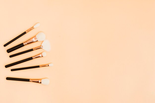 Various type of makeup brushes on beige background