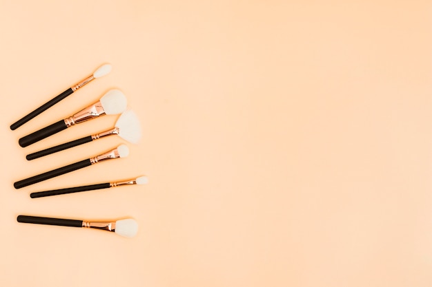 Various type of makeup brushes on beige background