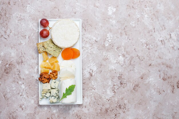 Various types of cheese on light  brown surface