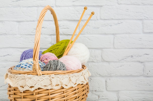 Various types of colorful wools in wicker basket
