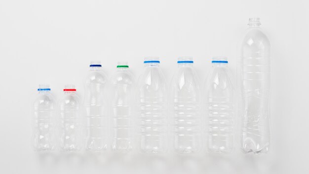 Различные виды пластиковых бутылок на сером фоне