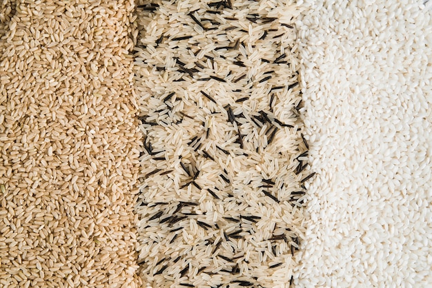 Various types of rices scattered on table 