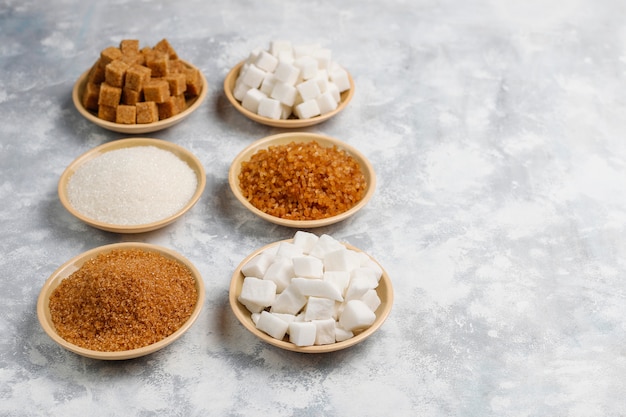 Various types of sugar, brown sugar and white on concrete ,top view