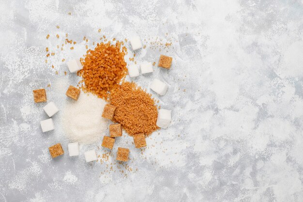 Various types of sugar, brown sugar and white on concrete ,top view