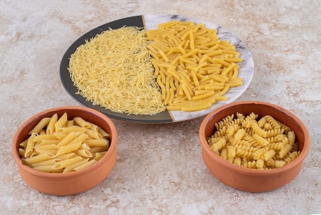 Various types of uncooked macaroni on a beautiful plate