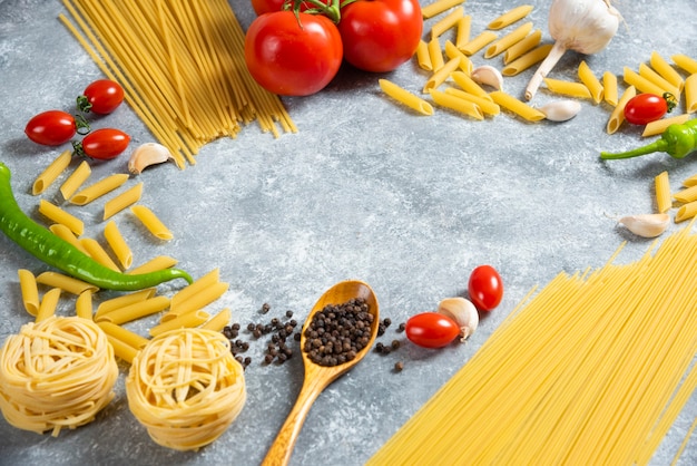 Various types of uncooked spaghetti with vegetables
