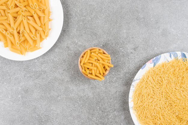 Various uncooked pasta on marble surface