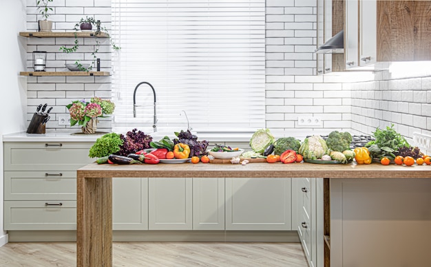 モダンなキッチンのインテリアを背景に、木製のテーブルにさまざまな野菜。