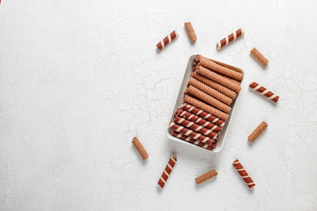 Various waffle rolls in ceramic plates, top view.