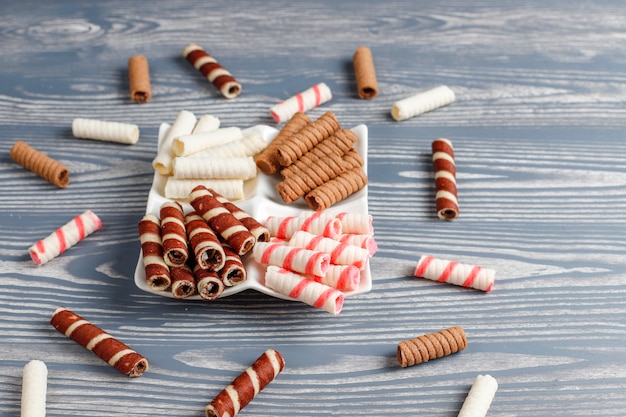 Various waffle rolls in ceramic plates,top view.