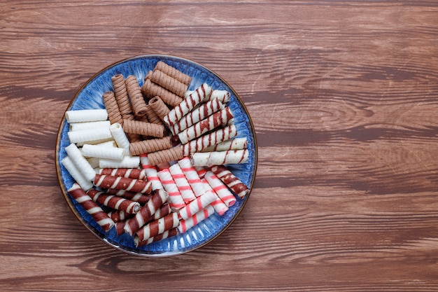 Various waffle rolls in ceramic plates,top view.