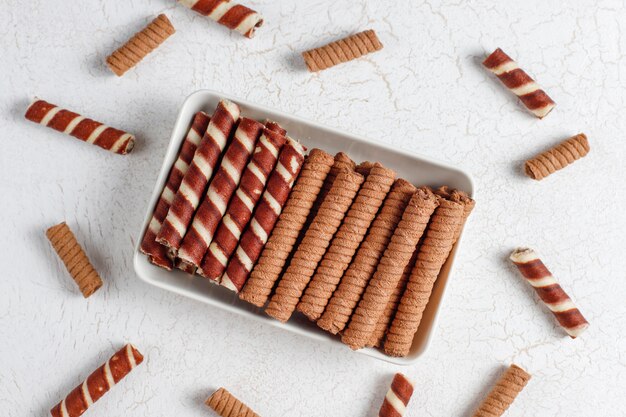 Various waffle rolls in ceramic plates,top view.