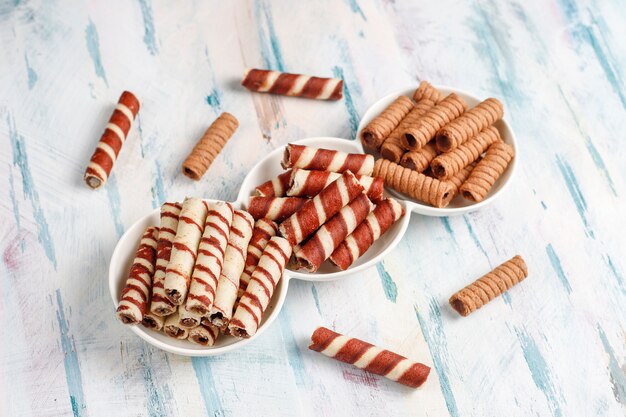 Various waffle rolls in ceramic plates,top view.