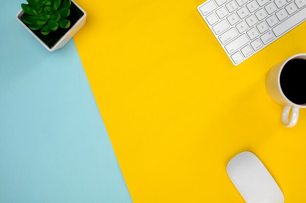 Various wireless devices on the yellow table and cup of coffee