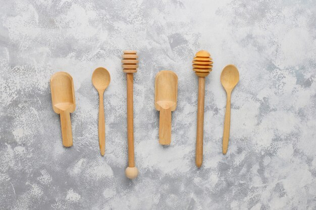 Various wooden spoons with handmade wooden cutting board on grey concrete 