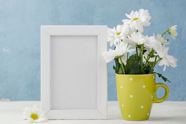 Vase with flowers beside frame