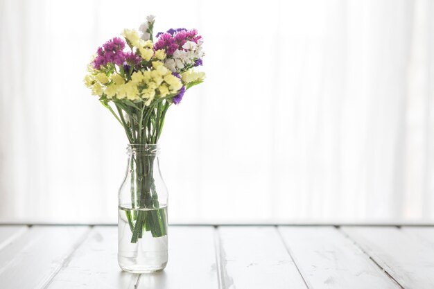 Vase with flowers on wooden table